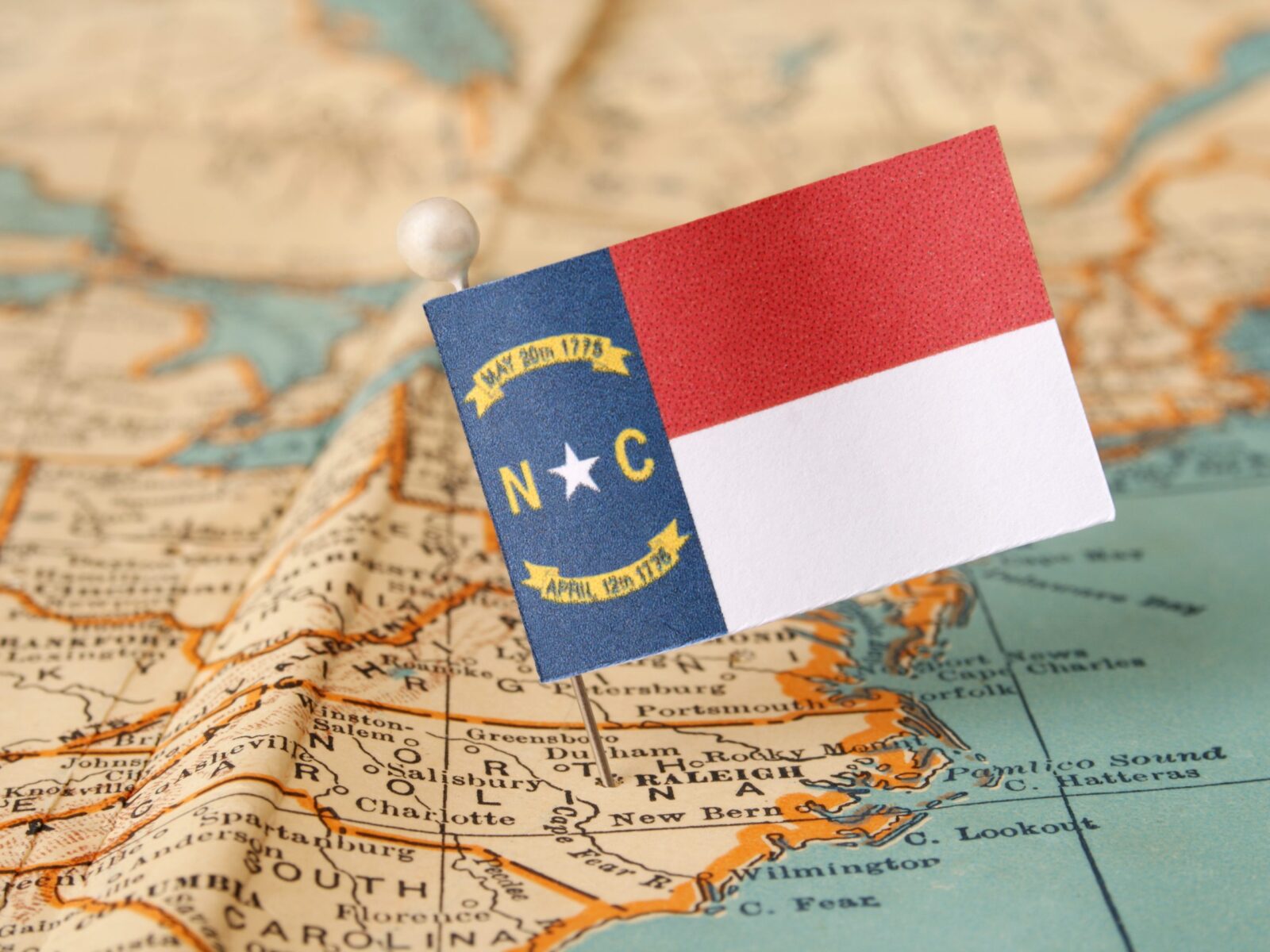 Map of North Carolina with a North Carolina Flag pinned into the map