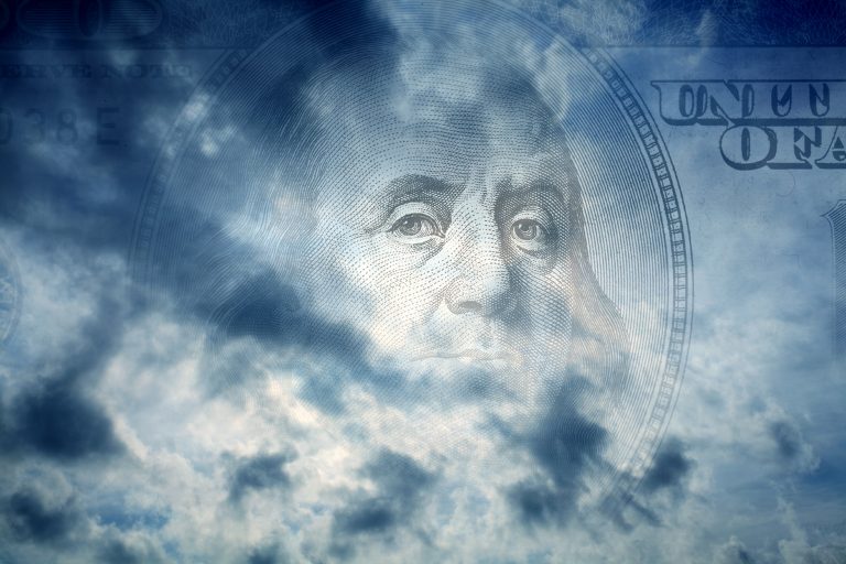 Dark storm clouds with the outline of a dollar bill in the background.
