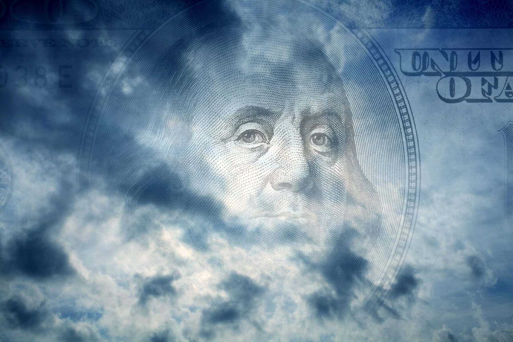 Dark storm clouds with the outline of a dollar bill in the background.
