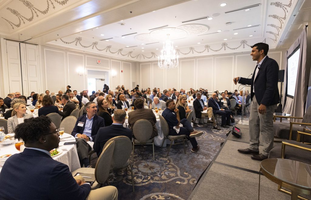 Speaker talking in front of audience at Frontiers of Business conference