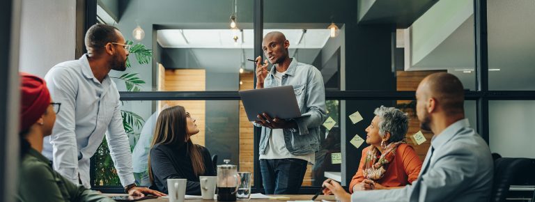 Business professionals having a discussion during a meeting in a modern office. Team of multicultural businesspeople sharing creative ideas in an inclusive workplace.