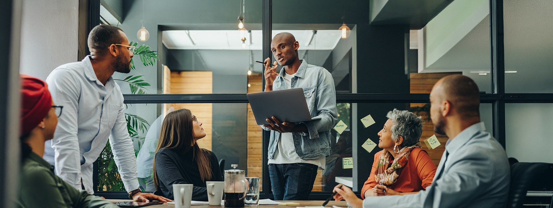 Business professionals having a discussion during a meeting in a modern office. Team of multicultural businesspeople sharing creative ideas in an inclusive workplace.