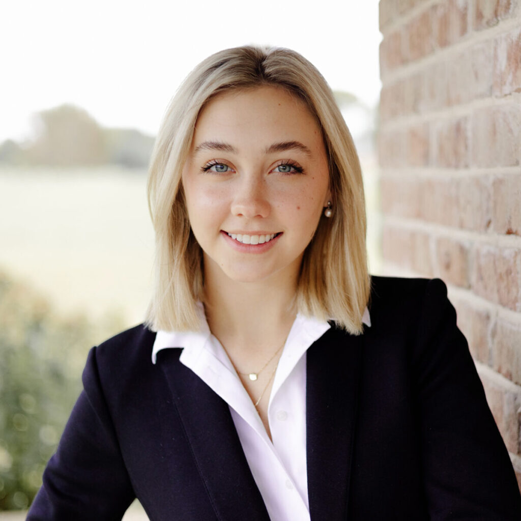 Headshot of a woman with shoulder length blonde hair wearing a blazer and smiling